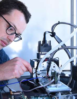 Engineer looking down microscope